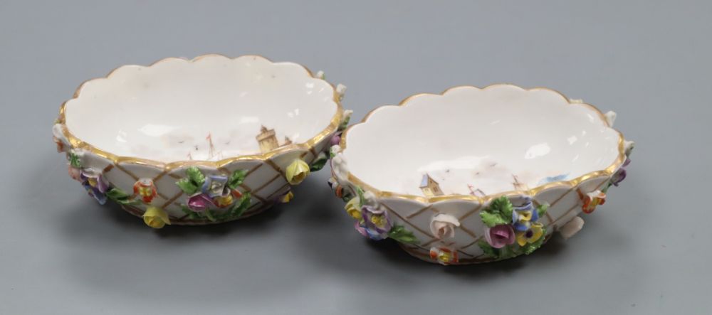 A pair of Helena Wolfsohn Dresden oval basket moulded salts, painted with harbour scenes and encrusted with flowers